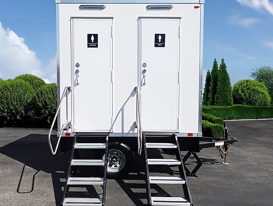 Example two-stall white restroom trailer with separate entrances and steps